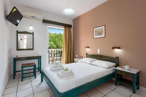 een slaapkamer met een groot bed en een balkon bij Eriva Hotel in Acharavi