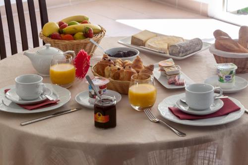 a table with a breakfast of bread and orange juice at BRIT HOTEL Le Lion d'Or CHINON in Chinon