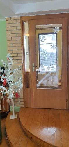 a room with a christmas tree in front of a door at Kraljevi Konaci Olja in Zlatibor