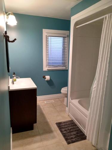 a bathroom with a toilet and a sink and a tub at Toronto Furnished Living- Niagara Falls in Niagara Falls