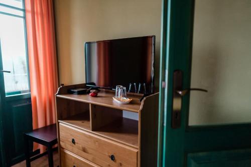 Un dormitorio con un tocador con TV. en Na Kopečku AD 1795 - penzion, restaurace, privátní wellness, en Dvůr Králové nad Labem