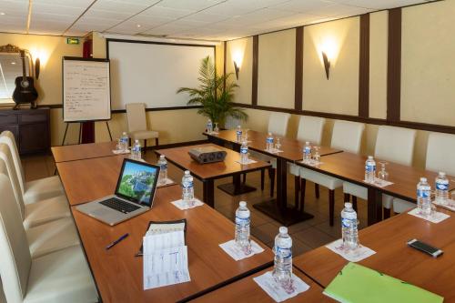 a conference room with a laptop on a table at BRIT HOTEL Le Lion d'Or CHINON in Chinon