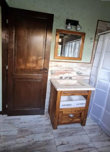 a bathroom with a sink and a mirror and a door at Cabañas Altos de San Blas in San Javier