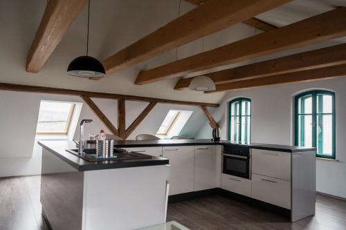 a kitchen with white cabinets and a black counter top at Na Kopečku AD 1795 - penzion s restaurací a wellness v Podkrkonoší in Dvůr Králové nad Labem