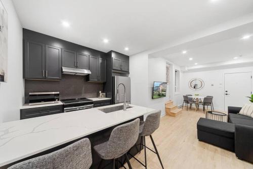 a kitchen and living room with black cabinets and a counter at Stonewall Suites in Montréal