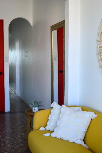 a yellow couch in a room with a red door at Digital Nomad San Agustin Apartments in San Juan