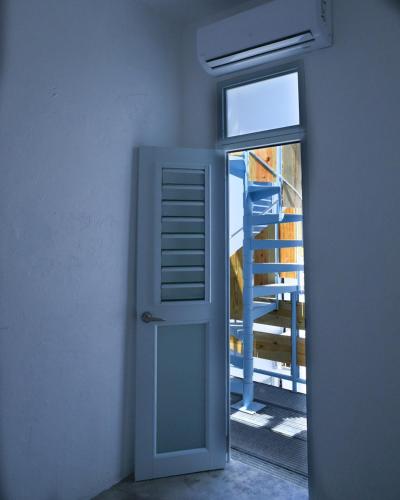 an open door leading to a window with a ladder at Digital Nomad San Agustin Apartments in San Juan