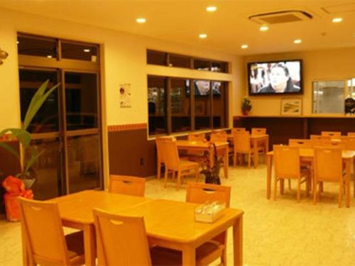 a restaurant with tables and chairs and a flat screen tv at Yugaku Resort Kimukura - Vacation STAY 93867v in Tokunoshima