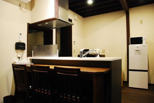 cocina con encimera con sillas y nevera en Kanazawa Hitomuneyado Kaisen - Vacation STAY 94237v, en Kanazawa