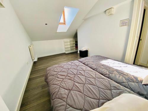 a attic bedroom with two beds and a window at Panoramico Uno in Cuenca