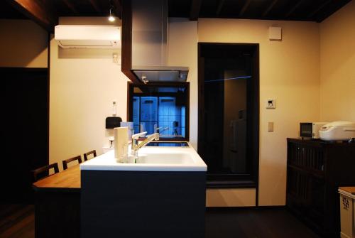 cocina con lavabo blanco y espejo en Kanazawa Hitomuneyado Kaisen - Vacation STAY 94237v, en Kanazawa
