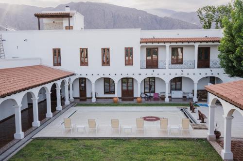 an exterior view of a white building with a courtyard at Iraola Hotel Boutique in Cafayate