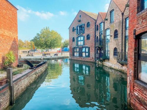 a canal in a city with buildings and water at Riverside loft apartment in Newport