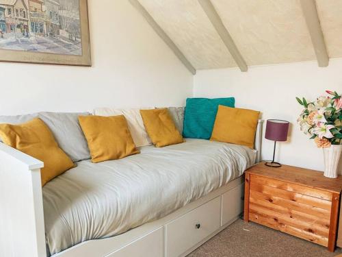 - un canapé avec des oreillers jaunes et bleus dans l'établissement Riverside loft apartment, à Newport