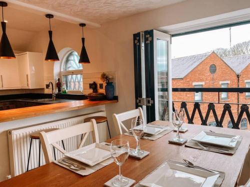 a dining room with a table with chairs and a window at Riverside loft apartment in Newport