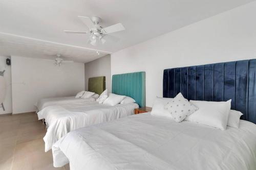 a room with two beds and a ceiling fan at +MS +Casa Limón +16 Pax +Wifi 150Mb in Querétaro