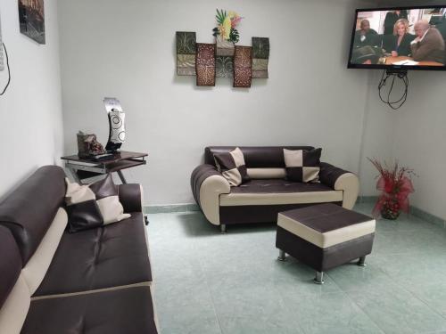 sala de estar con 2 sofás y TV en Hotel Mirador Plaza, en Pereira