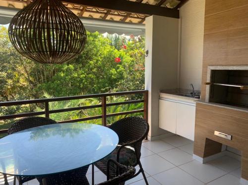 a kitchen with a table and chairs and a balcony at Condomínio Lírios Paraíso de Paz e Beleza in Mata de Sao Joao
