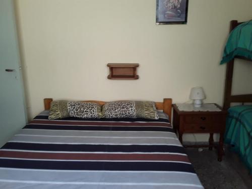 1 dormitorio con 1 cama con rayas azules y blancas en Departamento 6 personas con vista al mar en Mar de Ajó