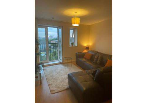 a living room with a couch and a window at 3 Bedroom Beautiful Apartment in Manchester