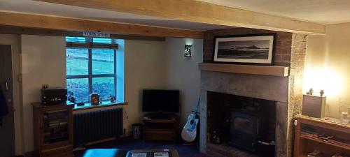 Uma televisão e/ou sistema de entretenimento em Colts Neck Cottage Upper Hopton, Mirfield, West Yorkshire
