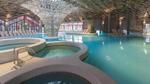 a large swimming pool with a hot tub in a building at Apartma PeMaks, Terme Olimia in Podčetrtek