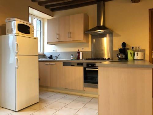 a kitchen with a white refrigerator and a stove at Gîte du Morvan in Saint-Germain-des-Champs