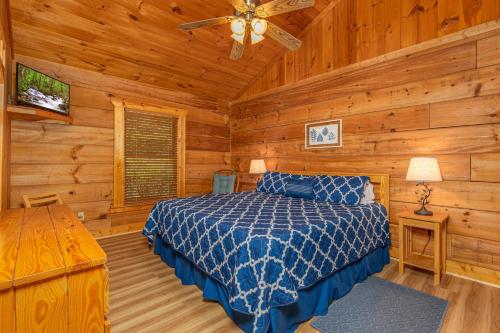 1 dormitorio con 1 cama en una cabaña de madera en Firefly Hollow Cabin - Smoky Mountains - Soaky Mountain Water Park - Sevierville Convention Center, en Pigeon Forge