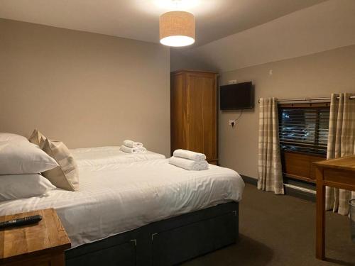 a bedroom with a large bed with towels on it at Duke Of York in Hazel Grove