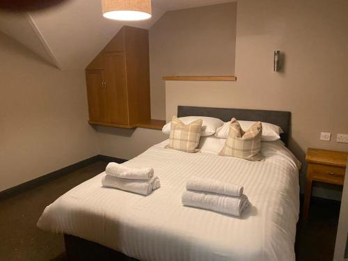 Un dormitorio con una cama blanca con toallas. en Duke Of York en Hazel Grove