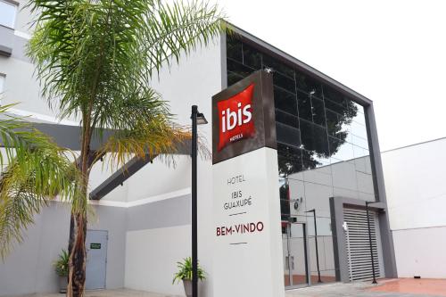 un edificio con una señal de td delante de él en Ibis Guaxupe en Guaxupé