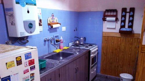 a small kitchen with a sink and a stove at Departamento 2 ambientes PB a metros del mar in Mar de Ajó