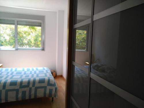 サン・アドリア・デ・ベソスにある2 BEDROOMS and 2 BATHROOMS FOR 5 PAX, SWIMMING POOL, FREE PARKING and NEAR THE BEACH!のベッドルーム1室(ベッド1台、ガラス張りのクローゼット付)