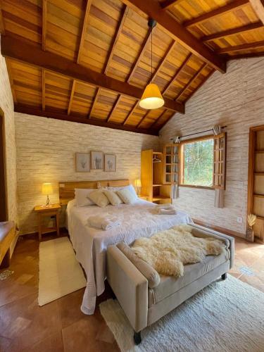 Flor de Minas في مونتي فيردي: غرفة نوم بسرير كبير وسقف خشبي