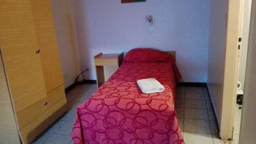 a small bedroom with a red bed with a white phone on it at Bet Hotel Buenos Aires in Buenos Aires