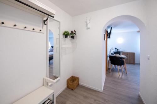 einen Flur mit einem Spiegel und einem Tisch in einem Zimmer in der Unterkunft Agrimonia - möbilierte Ferienwohnung mit Balkon in Davos