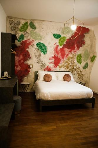 ein Schlafzimmer mit einem Bett und einer Wand mit Pflanzen in der Unterkunft BED and BREAKFAST il Duomo in Ascoli Piceno