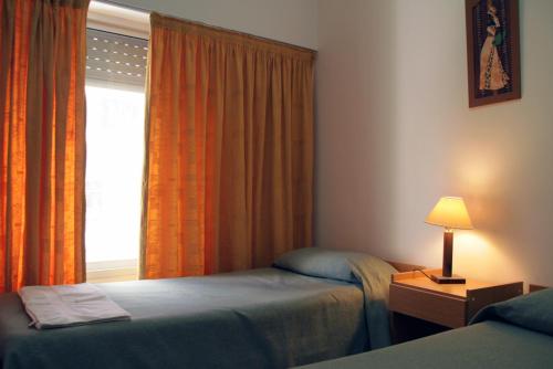 a hotel room with two beds and a window at Bet Hotel Buenos Aires in Buenos Aires