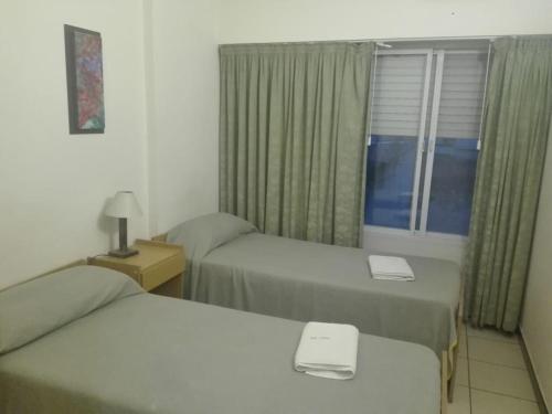 a hotel room with two beds and a window at Bet Hotel Buenos Aires in Buenos Aires