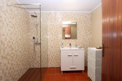 ein Badezimmer mit Waschbecken und Glasdusche in der Unterkunft Monte Mar House in Ribeira Grande