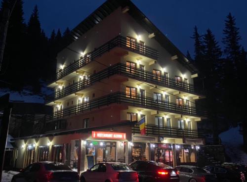 a building with cars parked in front of it at night at Hotel Restaurant Alessia in Ranca