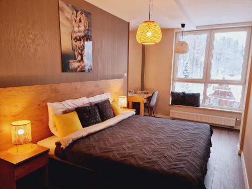 a bedroom with a large bed and a window at Apartament SPA 40 Resort Kozubnik blisko Szczyrk - 5D Apartamenty in Porąbka