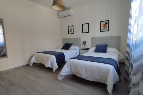 two beds in a room with white walls at La Casa del Cerrillo in Sonseca