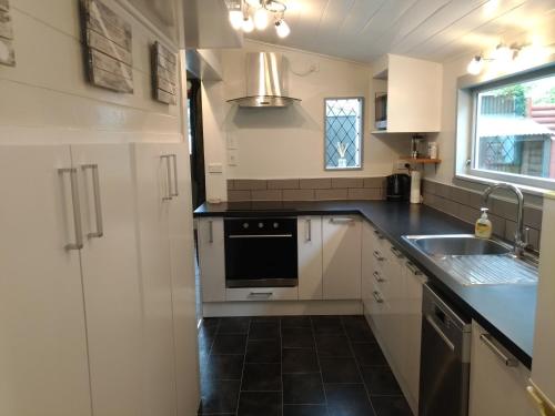 a kitchen with a sink and a stove at Milton Cottage in Napier