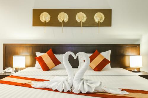 two white swans making a heart shape on a bed at Fifth Pattaya Jomtien By Shiwalai Int in Jomtien Beach