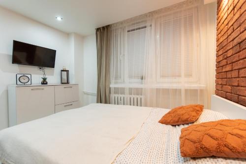 sypialnia z białym łóżkiem i telewizorem w obiekcie Apartament Jasnogórska w mieście Częstochowa