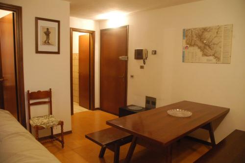 a living room with a wooden table and a table and chair at Appartamento Cerreto Laghi in Cerreto Laghi