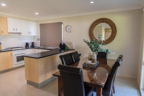 a kitchen with a table and a dining room at McMillans of Metung Coastal Resort in Metung