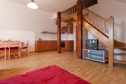 sala de estar con escalera y TV en Vineyard Cottage Lustek, en Novo Mesto