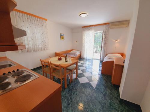 a room with a kitchen and a table and a bed at Apartments Villa Anne in Jadranovo